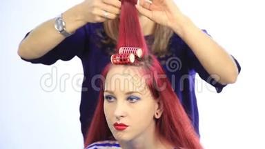 女<strong>造</strong>型师为<strong>年轻</strong>的红头发妇女创<strong>造</strong>了一个大卷发的完美发型